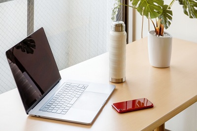 机の上に置いてあるMacbookとiPhone